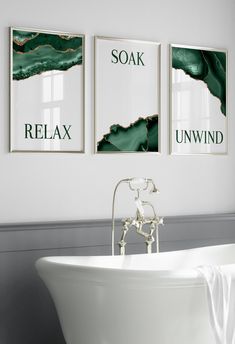 a white bath tub sitting next to two pictures on the wall