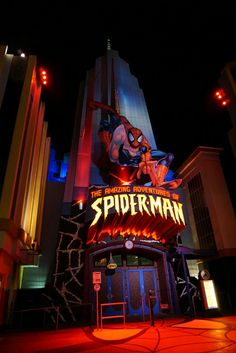 the entrance to spider - man theater at night