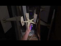 a person is reaching for something on the floor in front of a ceiling fan that's attached to a wall