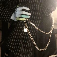 a person wearing a black and white striped shirt holding a silver chain around their waist