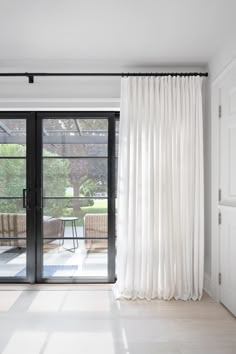 a living room with sliding glass doors and white curtains