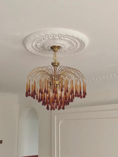 a chandelier hanging from the ceiling in a room with white walls and doors