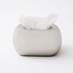 a white tissue dispenser sitting on top of a white tablecloth covered surface