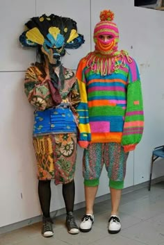 two people standing next to each other wearing colorful clothing