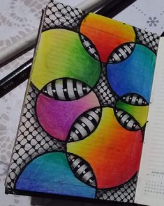 an open notebook with colorful designs on it