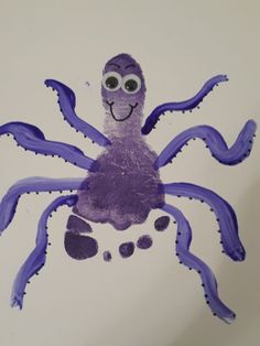 an octopus made out of purple paper with googly eyes on it's face