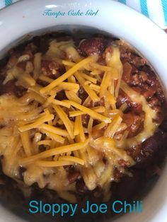 a white bowl filled with chili and cheese