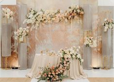 a table with flowers and candles on it in front of an artistic wallpapered backdrop