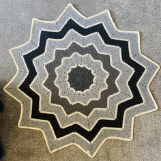 a black and white crocheted rug on the ground