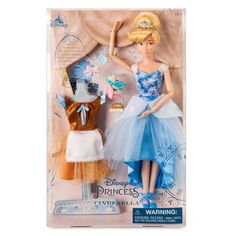 the doll is wearing a blue dress and standing next to another doll in front of a curtain