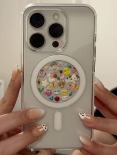 a woman holding up her phone case with stickers on it