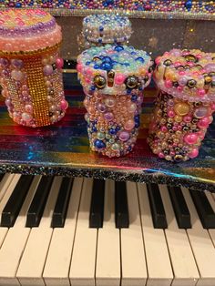 an assortment of colorful jewelry sitting on top of a piano