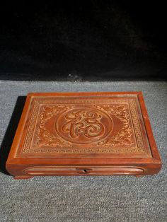 an old wooden box sitting on top of a carpeted floor next to a wall