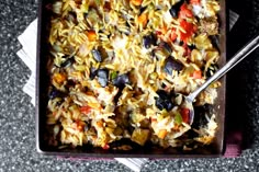 a pan filled with rice and vegetables on top of a table