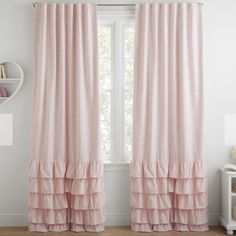 a pink curtain with ruffled edges in front of a window