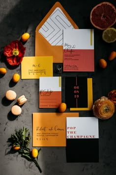 orange and black wedding stationery on top of each other with citrus slices around them