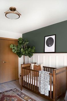 a baby's crib with a potted plant in the corner next to it