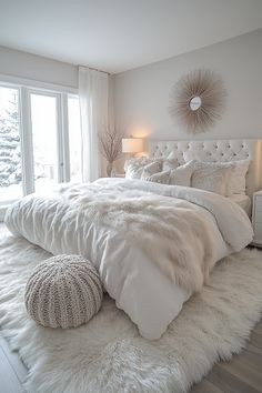 a bedroom with white fur on the floor and large bed in front of a window