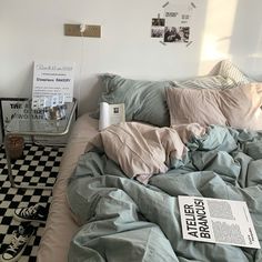 an unmade bed in a bedroom with black and white checkerboard flooring