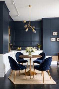 an elegant dining room with blue walls and white cabinets, gold chandelier over the table