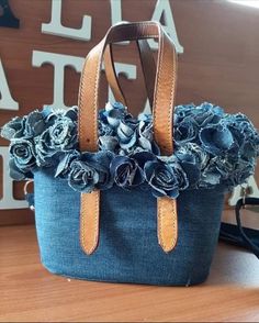 a denim bag with flowers on it sitting on a table