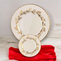 two white and gold plates sitting next to each other