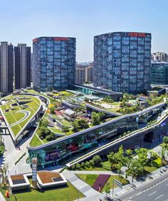 an aerial view of a city with tall buildings and green grass in the foreground