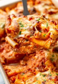 a spoon full of lasagna casserole being lifted from the casserole dish