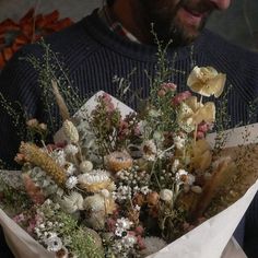 a man holding a bouquet of flowers in his hands