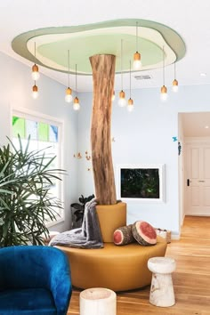 a living room filled with furniture and a large tree in the middle of the room