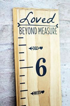 a wooden ruler with the words loved and beyond measure written in black ink on it