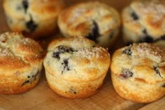 several blueberry muffins on a wooden cutting board