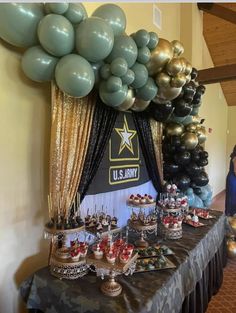 an army themed party with balloons and desserts on a table in front of a soldier's banner