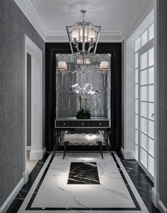 a black and white hallway with chandelier, marble flooring and large mirror