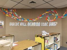 an office cubicle decorated with paper streamers and bookshelves for children's reading