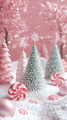 christmas trees and candy canes are in the snow with pink, white and red decorations