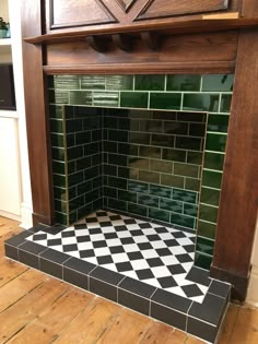 a black and white checkered tile fireplace in a room with wood flooring on the side