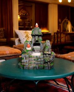 a table with a small castle on top of it in a room filled with couches and chairs