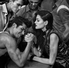 an old photo of two men and a woman sitting on the ground with their hands together