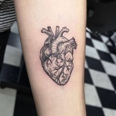 a black and white heart tattoo on the right arm, with an arrow in it