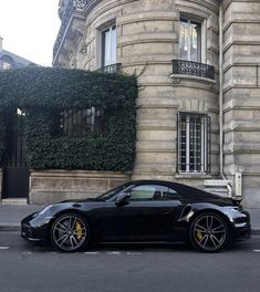 a black sports car parked in front of a building