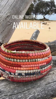 a stack of bracelets sitting on top of a wooden table next to the ocean