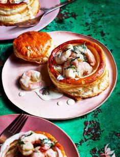 three pink plates topped with food on top of a green table