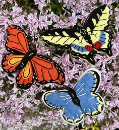 three butterflies are sitting on some purple flowers