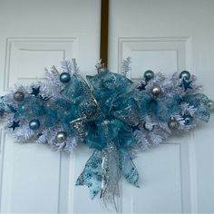 a blue and silver christmas wreath on the front door