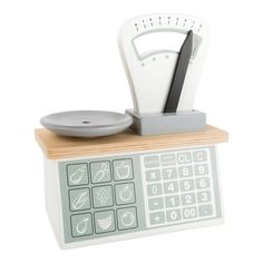 a kitchen scale with a cutting board and knife on it's stand next to a bowl