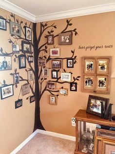 a family tree with pictures on the wall and framed photos hanging from it's branches