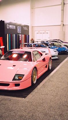 a pink car parked in front of a book shelf filled with books and other cars