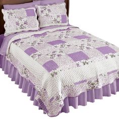 a bed with purple bedspread and matching pillows