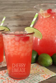 two glasses filled with watermelon and limeade sit next to each other on a table